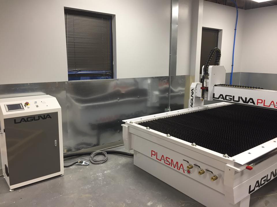A plasma cutter is sitting in a room next to a window.