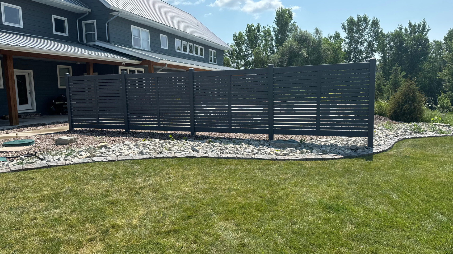 A black fence is in front of a large house.