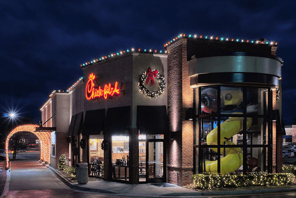 A chick fil a restaurant is decorated for christmas with christmas lights.