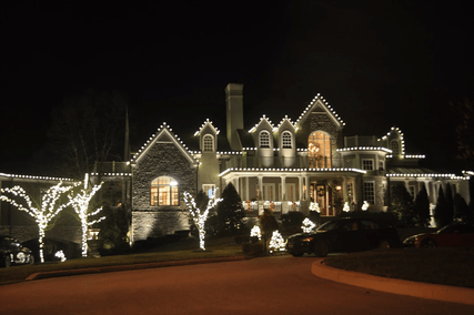 A large house is lit up with christmas lights at night