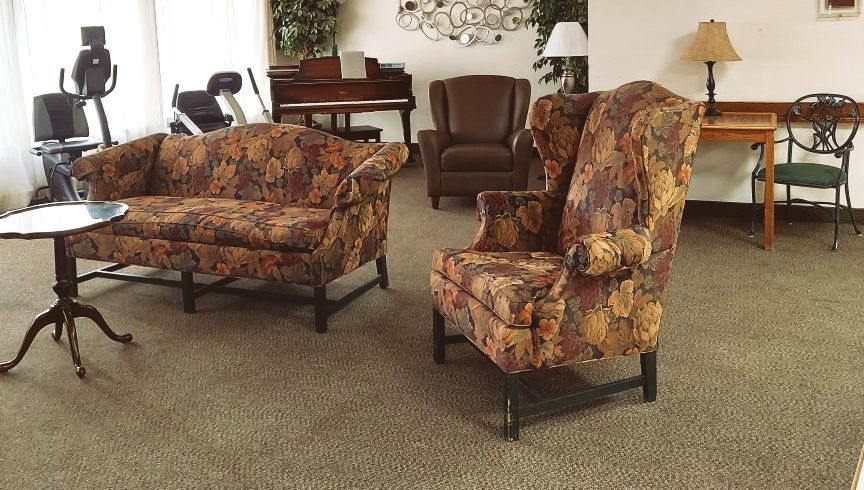A living room with a couch and two chairs