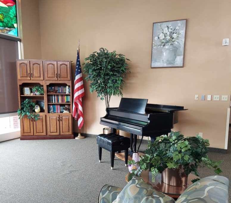 A living room with a piano and a picture on the wall