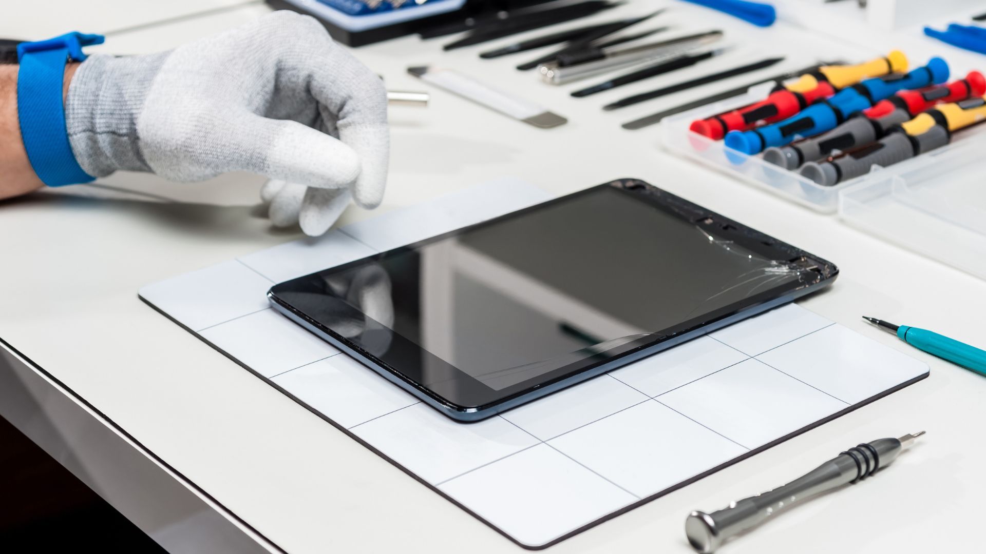 A person is fixing a tablet on a table.