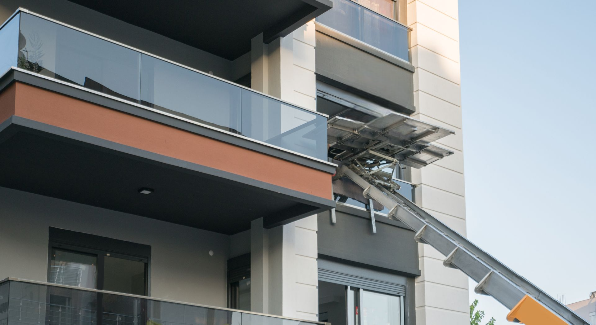 Un ascensore mobile si estende fino al balcone di un moderno condominio a più piani per trasportare mobili o oggetti personali.