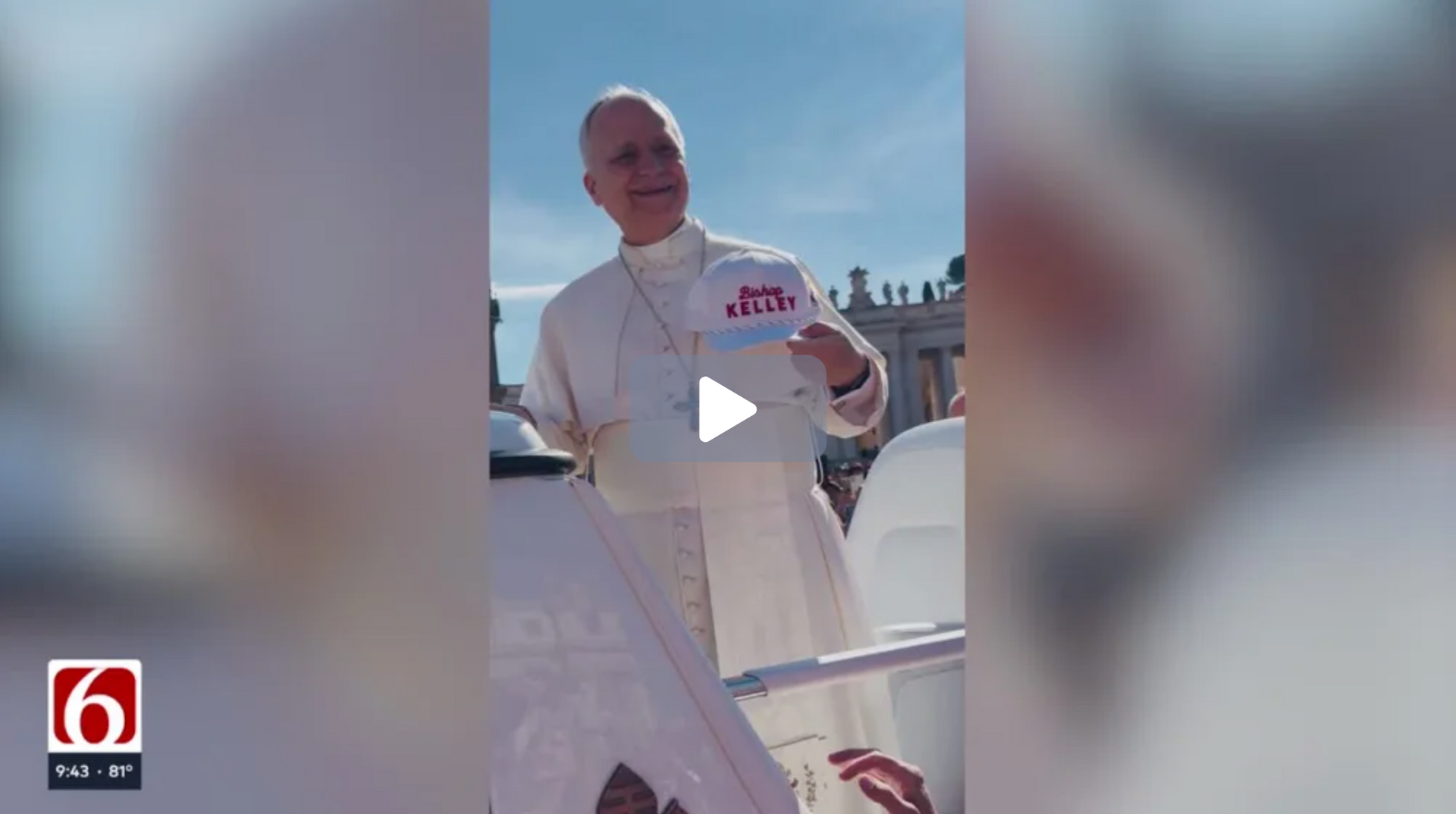 Pope Francis smiles while holding baseball cap that reads Bishop Kelley during a public appearance.