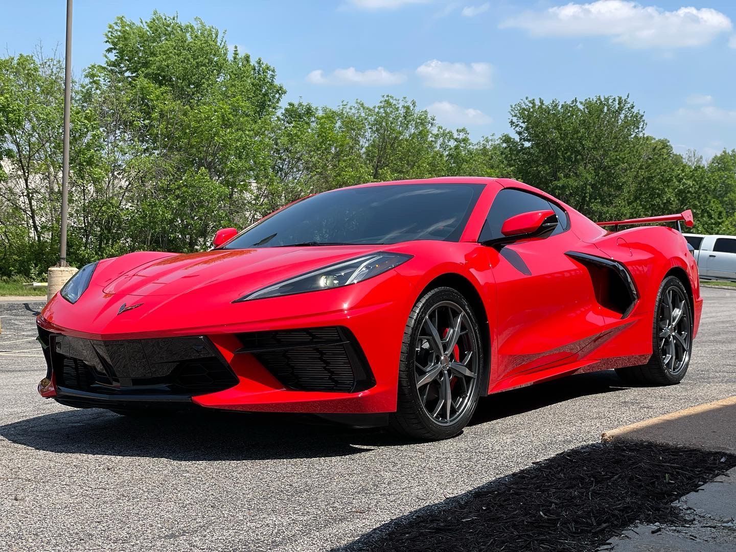 A red sports car is parked in a parking lot.