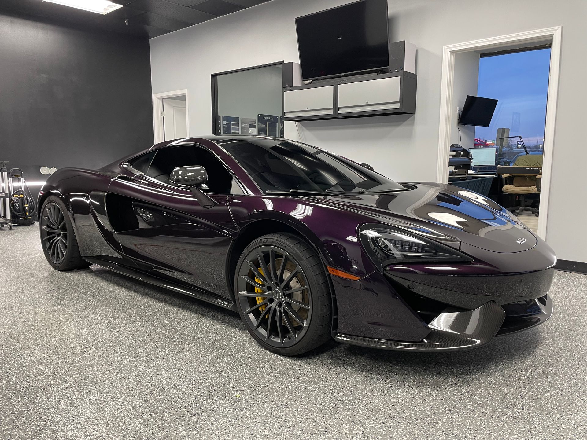 A purple sports car is parked in a garage.