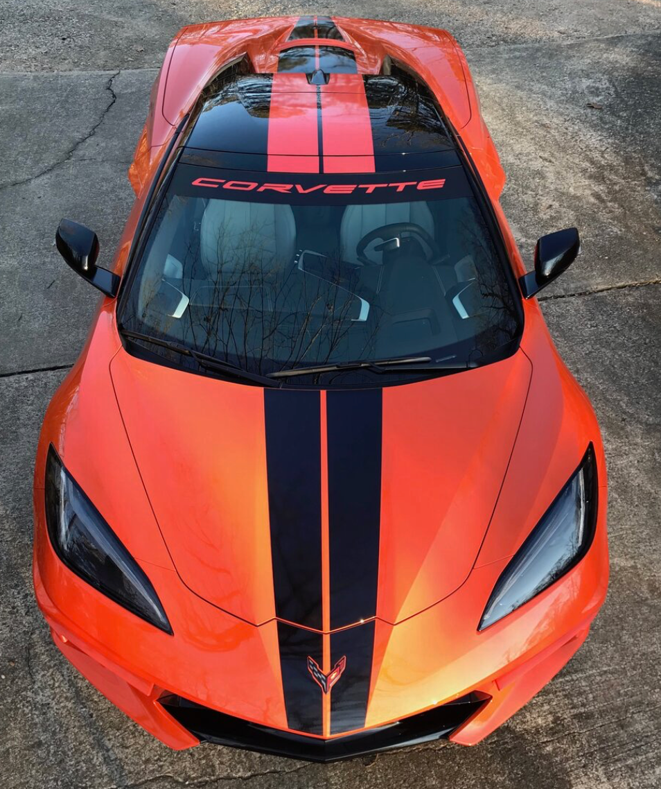 An orange corvette with black stripes on the hood