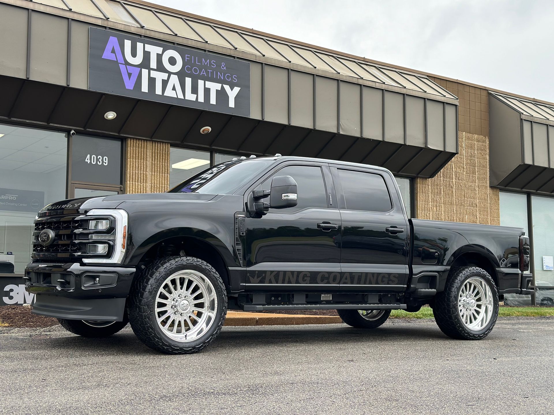 A black pickup truck is parked in front of a building.