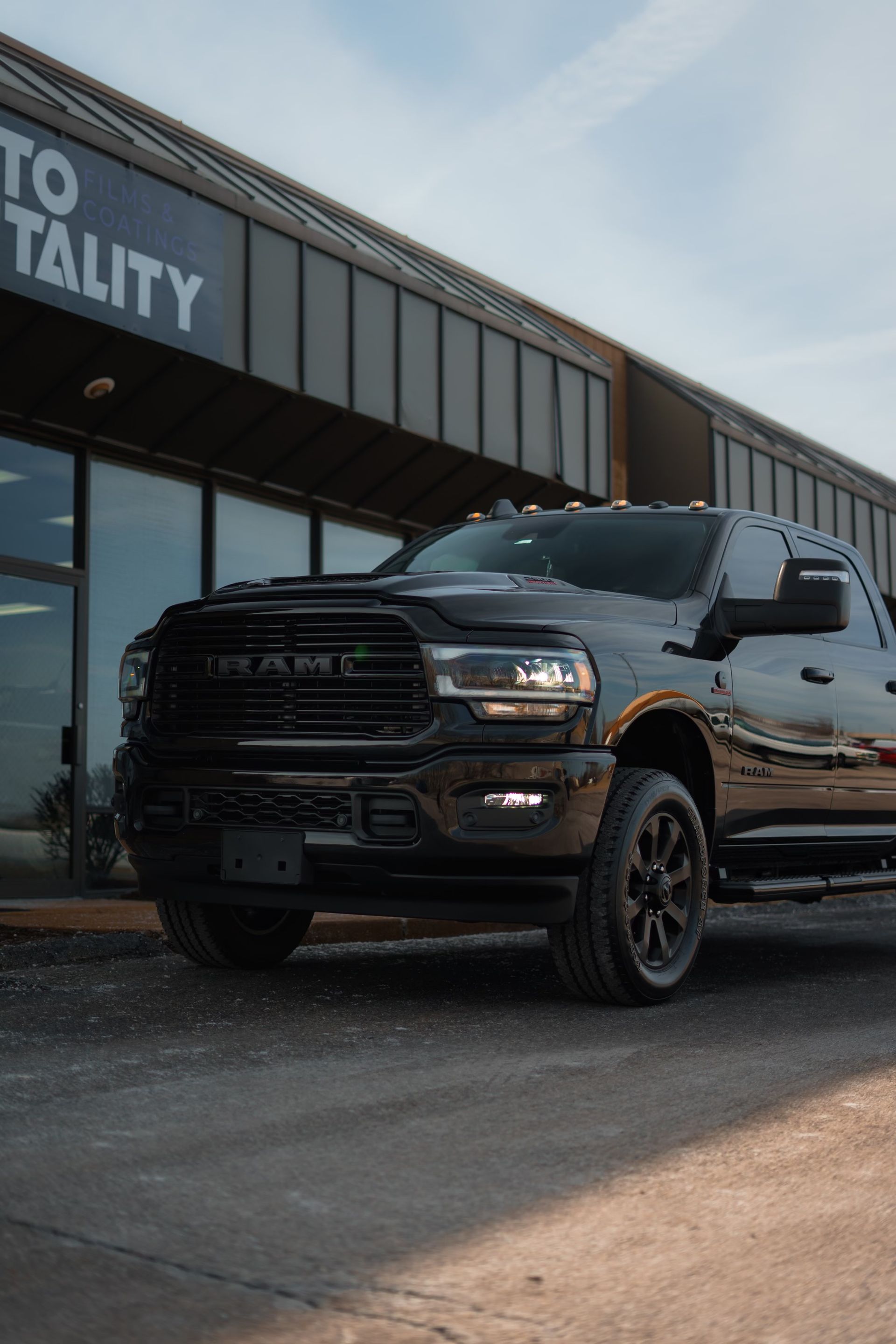 A black truck is parked in front of a building.