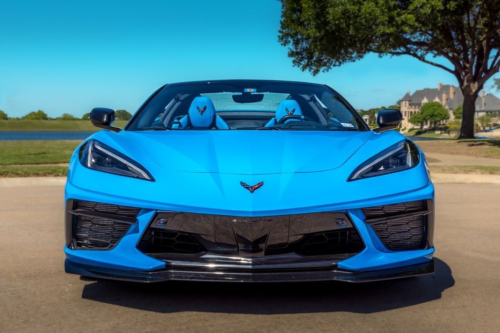 A blue sports car is parked on the side of the road.