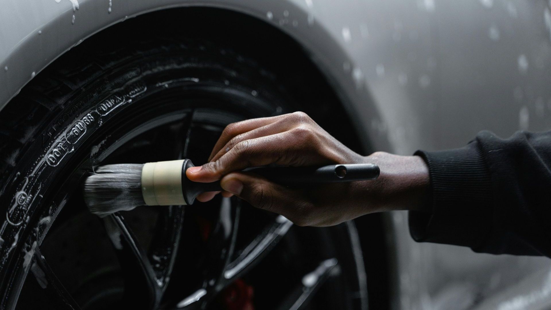 Washing a car wheel with a detailing brush