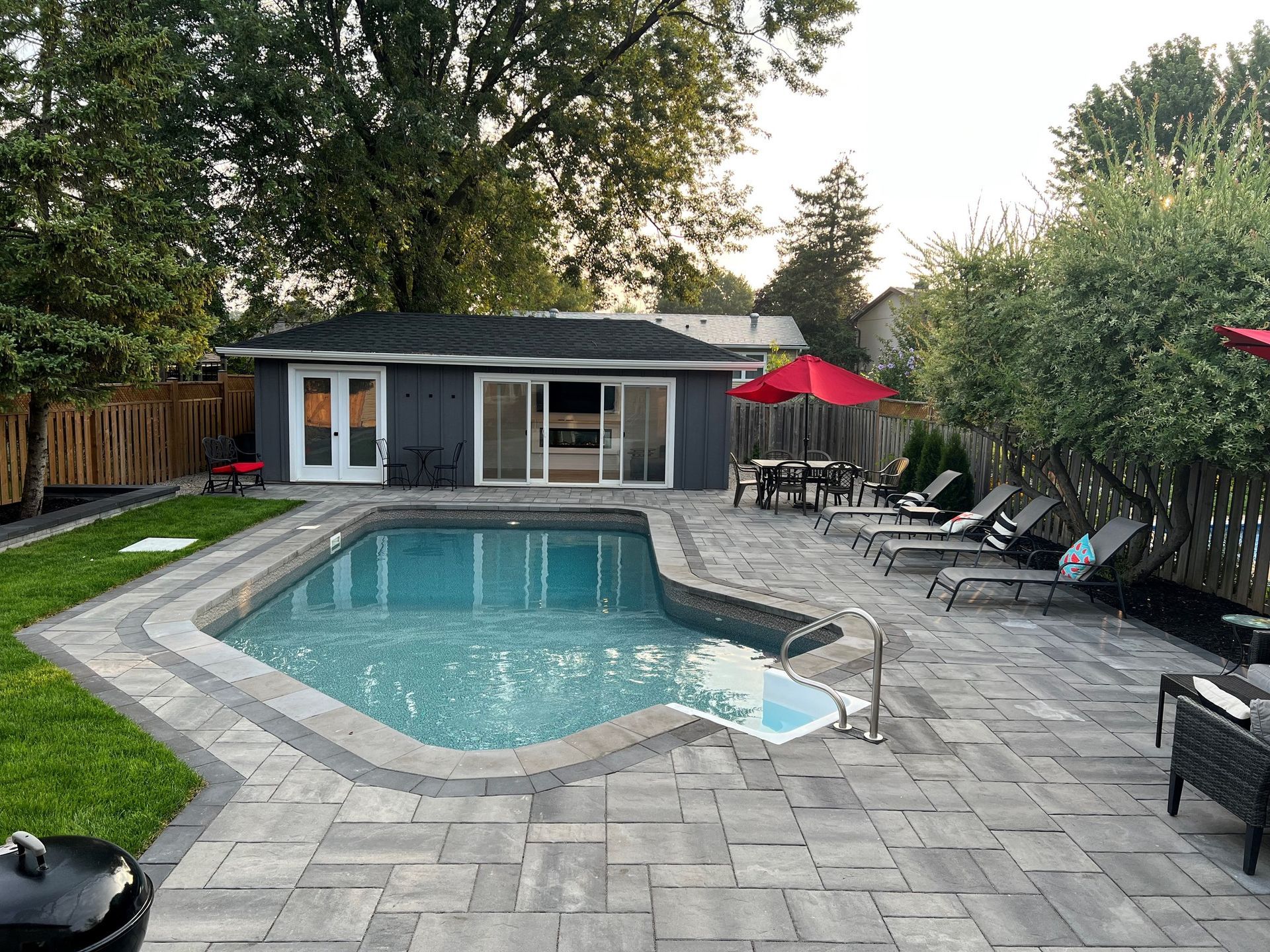 Man in black shirt holding coffee mug, smiling in a kitchen.