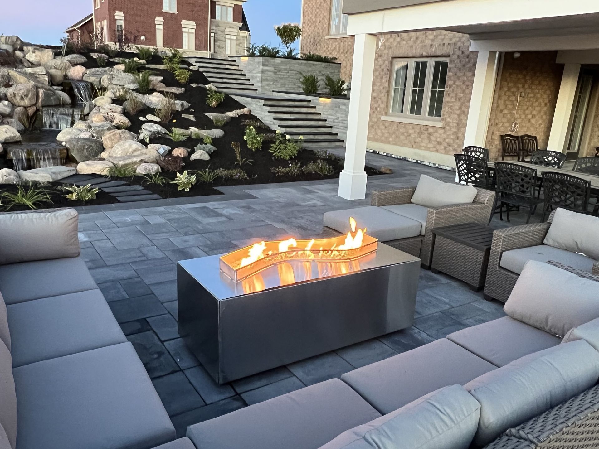Man in black shirt holding coffee mug, smiling in a kitchen.