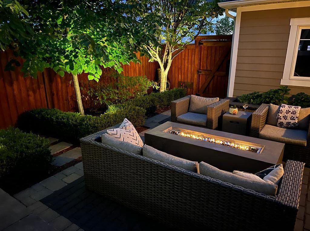 Man in black shirt holding coffee mug, smiling in a kitchen.