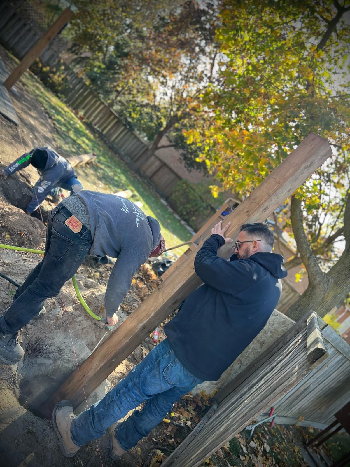 Man in black shirt holding coffee mug, smiling in a kitchen.