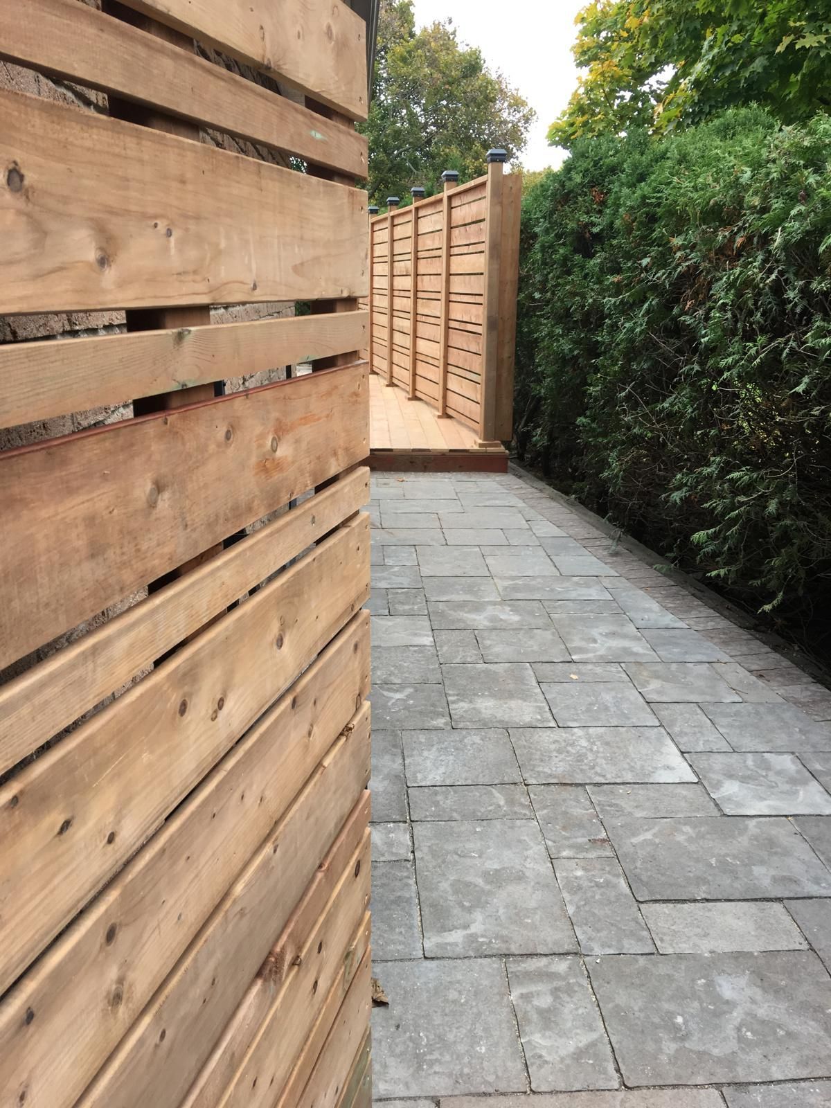 Man in black shirt holding coffee mug, smiling in a kitchen.