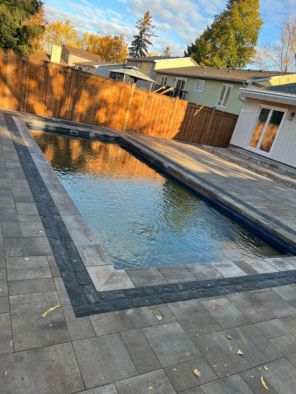 Man in black shirt holding coffee mug, smiling in a kitchen.