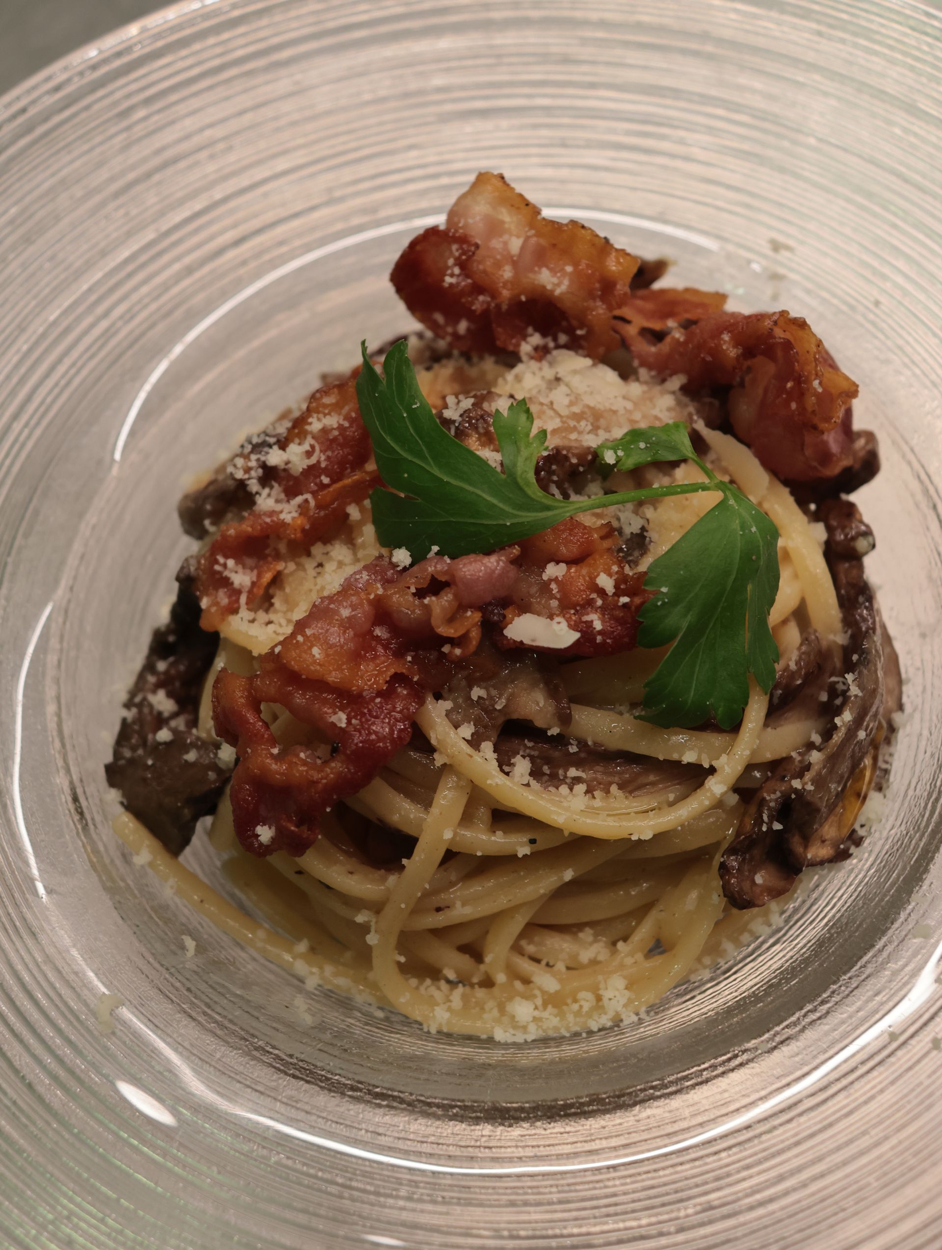 Antipasto di salmone affumicato e arancia su un cracker, guarnito con fiori di mimosa e servito su un piatto bianco.