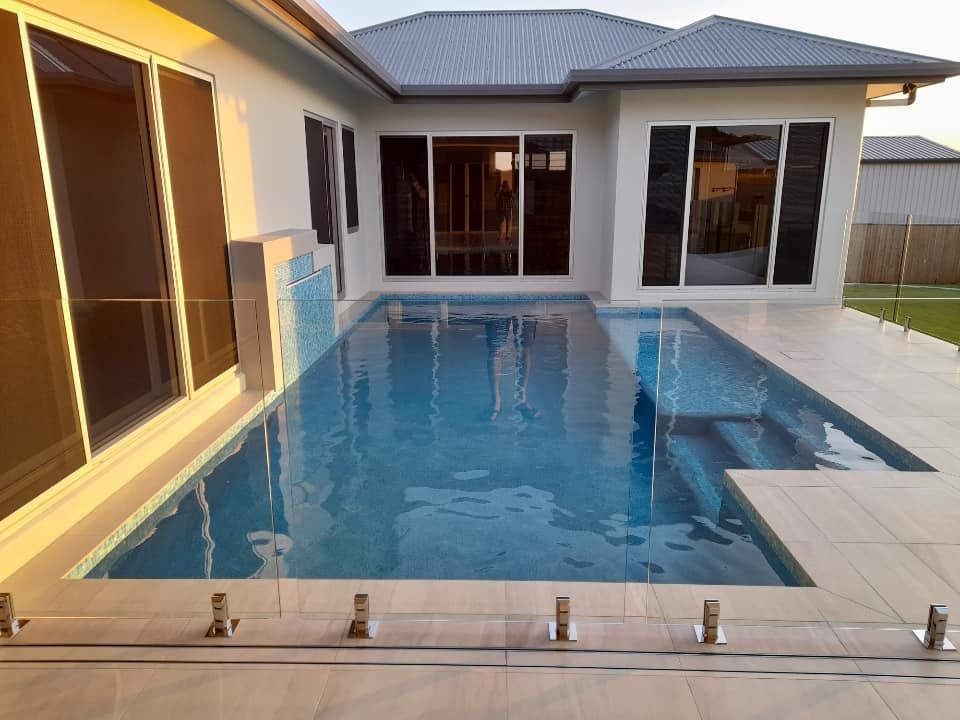 A Large Swimming Pool in The Backyard of A House — Pools Plus NQ in Kewarra Beach, QLD