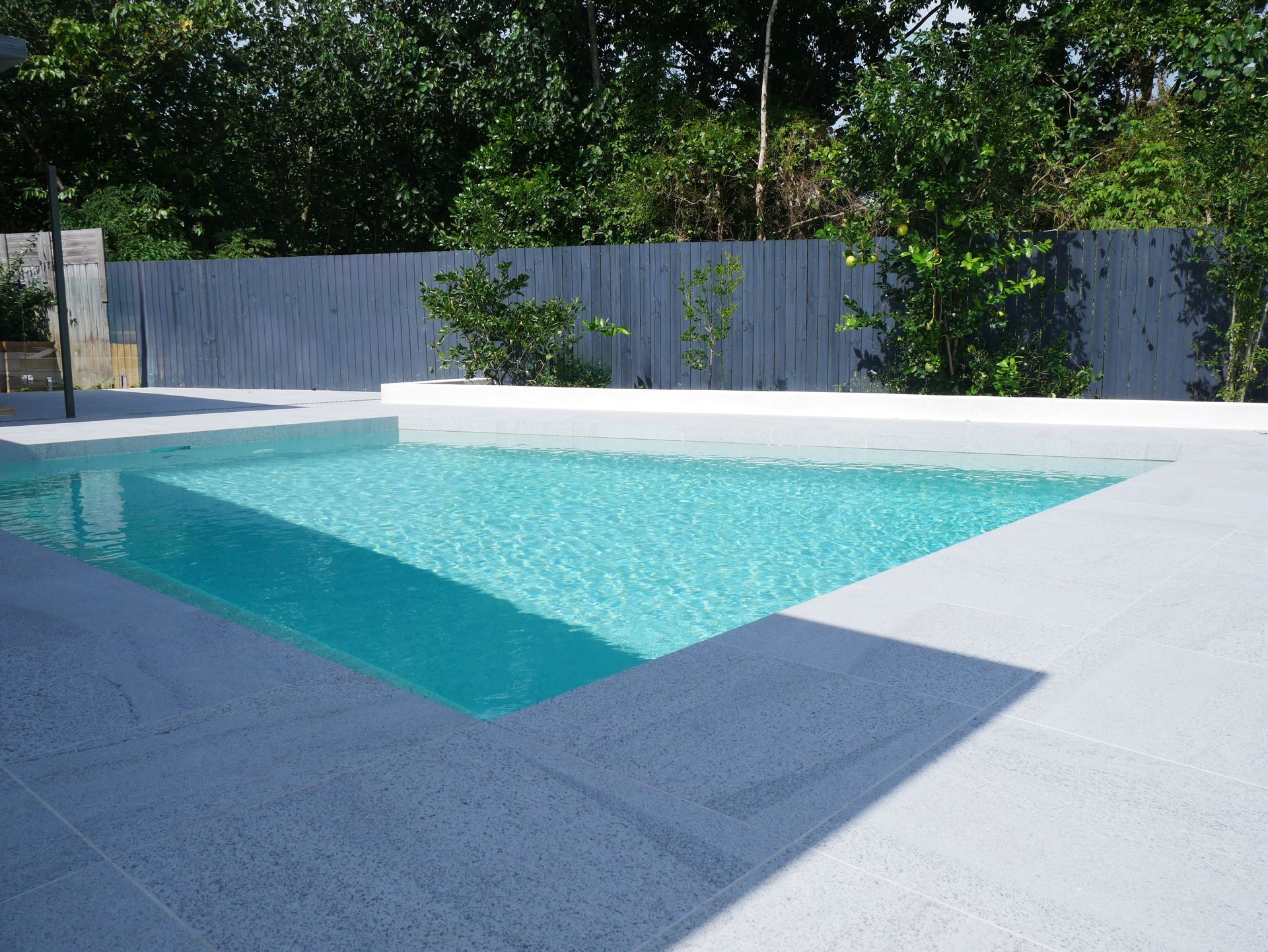 A Large Swimming Pool Is Surrounded by A Fence — Pools Plus NQ in Cairns, QLD
