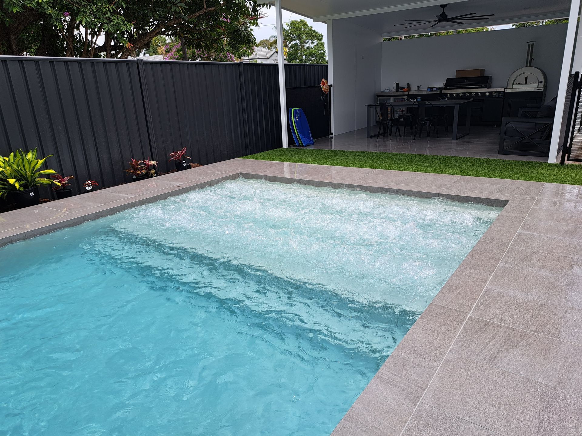 There Is a Large Swimming Pool in The Backyard of A House — Pools Plus NQ in Cairns, QLD