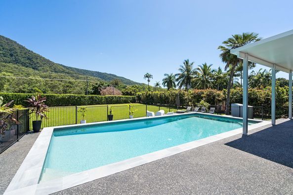 A Large House with A Swimming Pool in Front of It — Pools Plus NQ in Port Douglas, QLD 