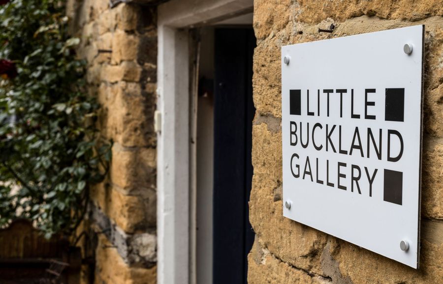 A sign on the side of a building that says little buckland gallery.