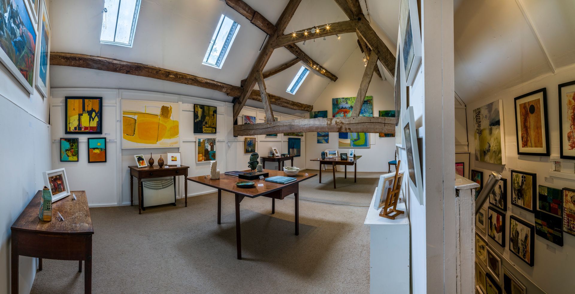 A corner of a room with paintings and a statue on display.