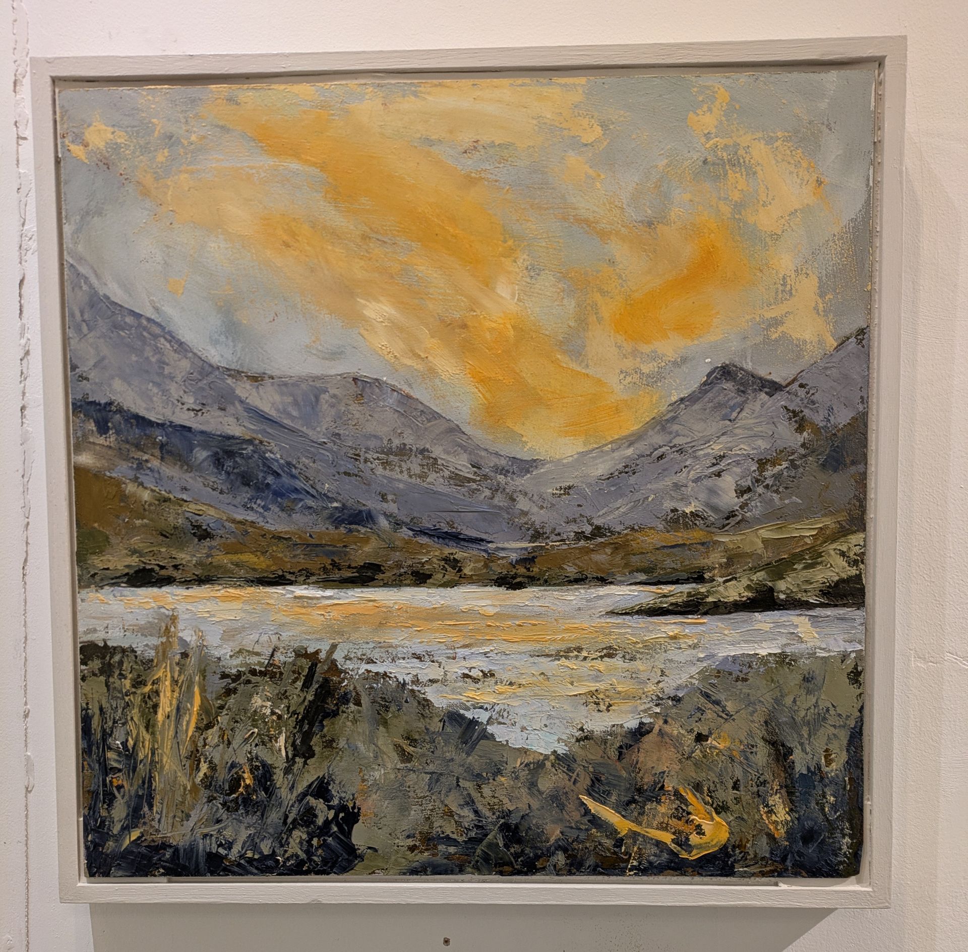 Oil painting of a mountain landscape with a lake, featuring yellows, blues, and grays.