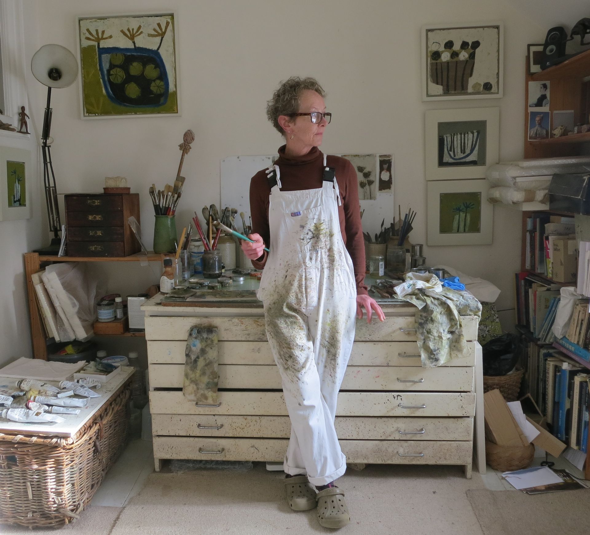 A woman is pointing at a painting on a wall