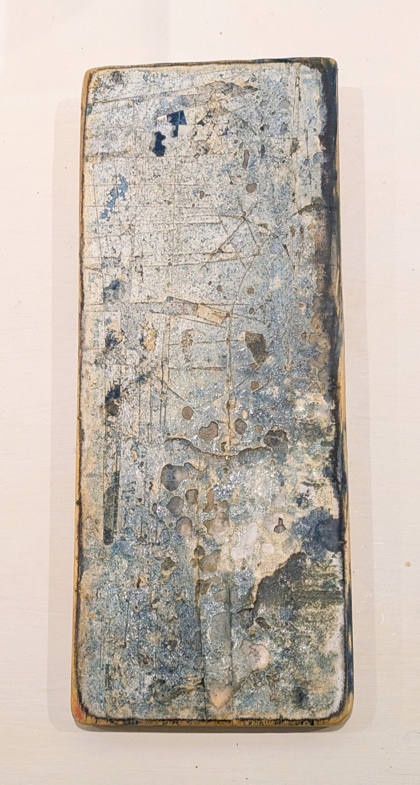 Weathered rectangular metal plate with a blue-gray, rust-speckled surface