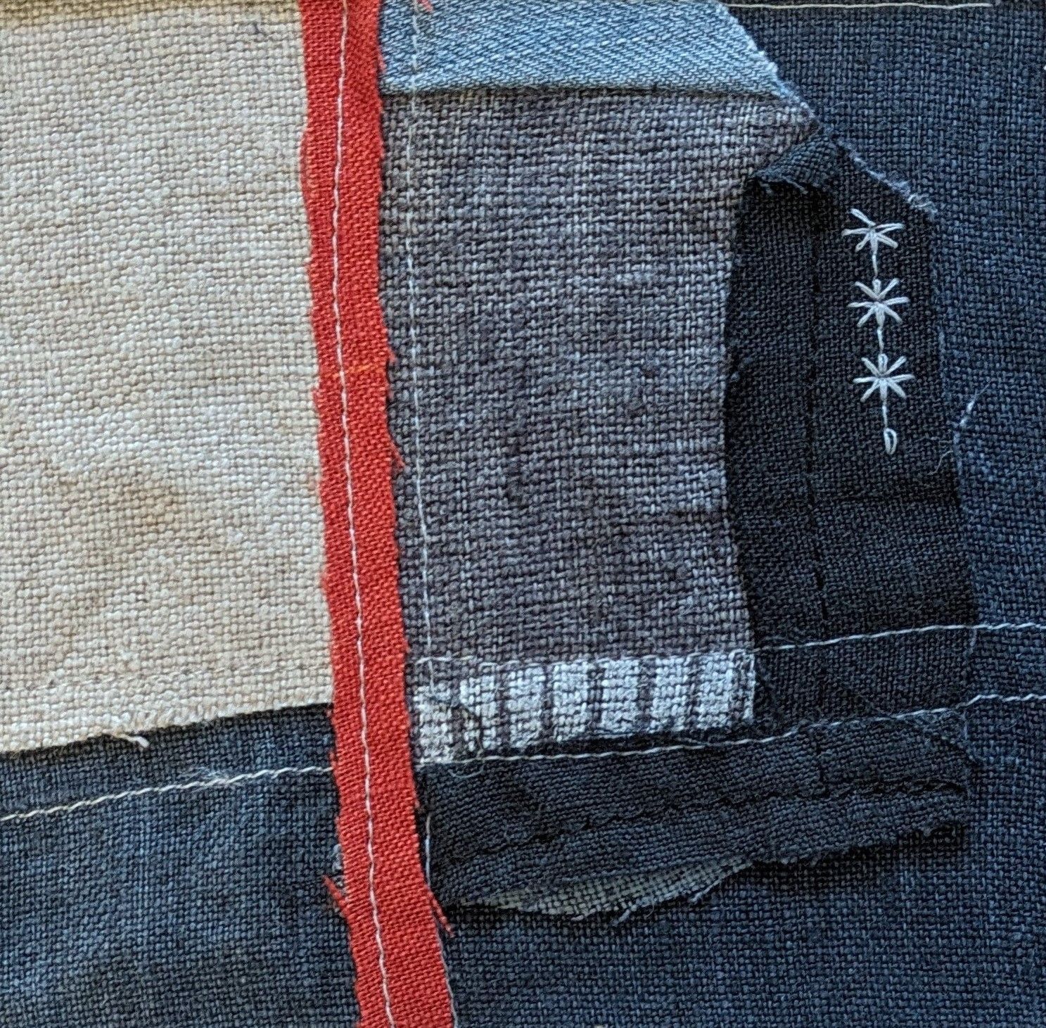 A close up of a piece of fabric with a red ribbon.