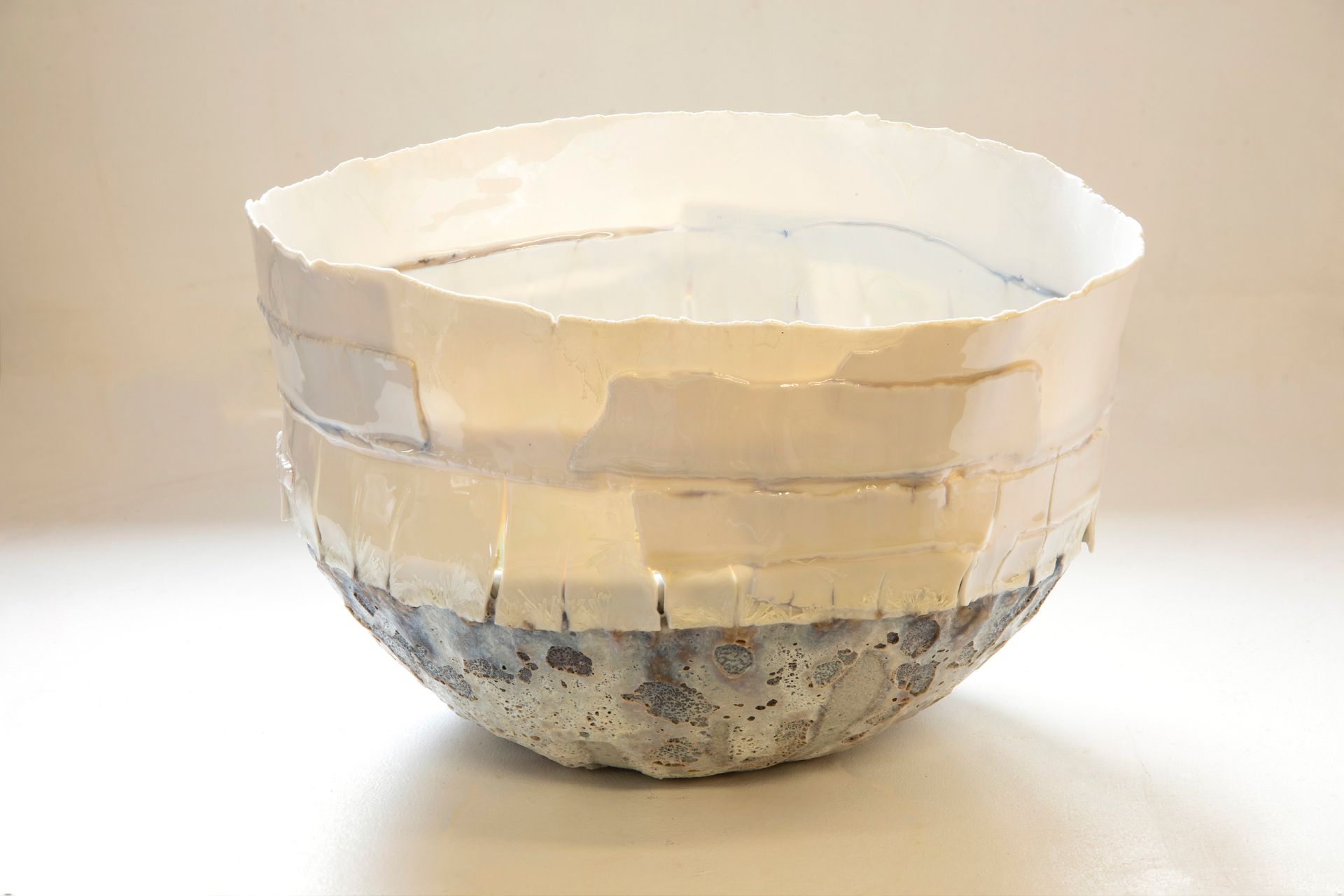 A white bowl is sitting on a white table.