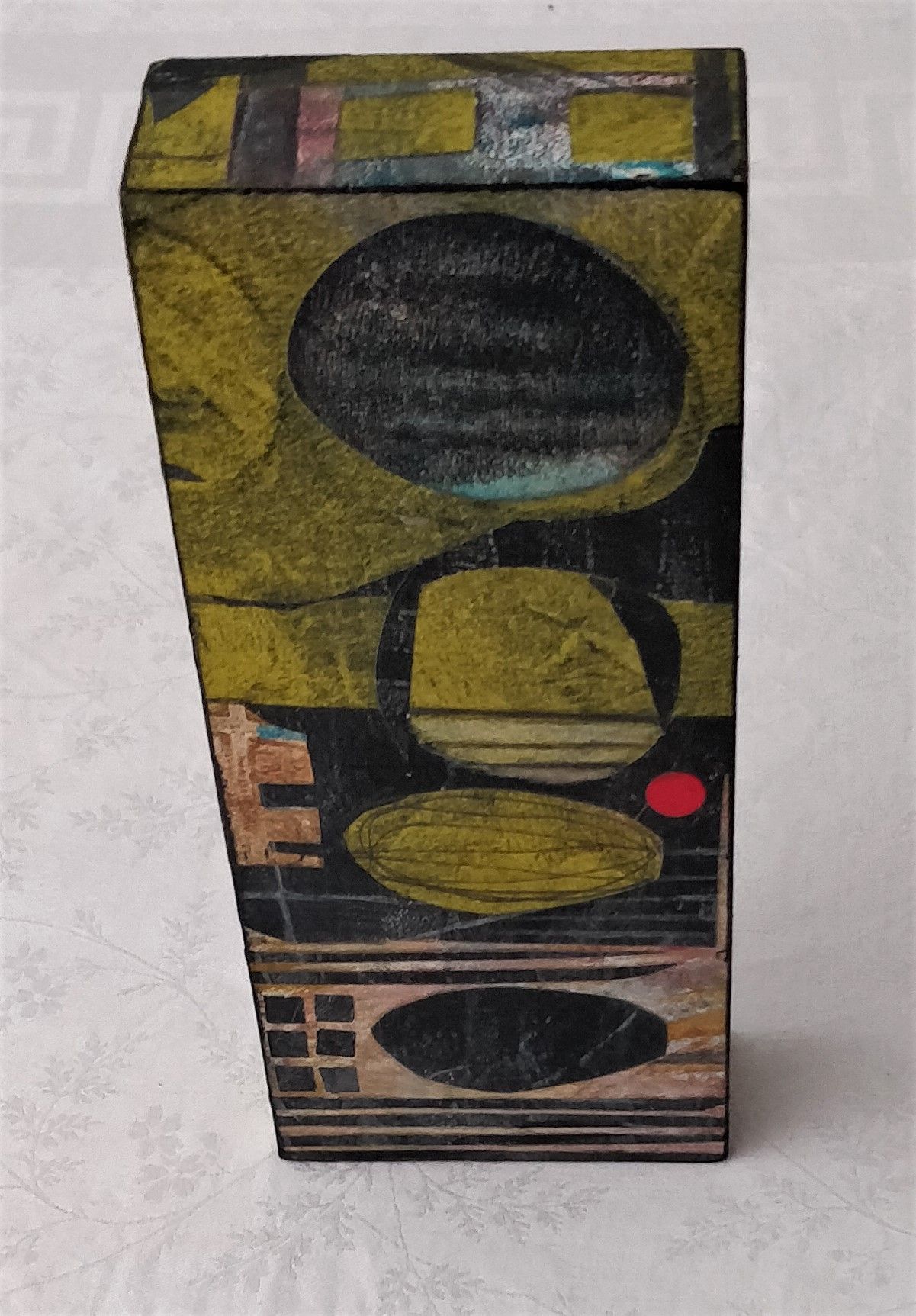 A box with a painting on it is sitting on a table.