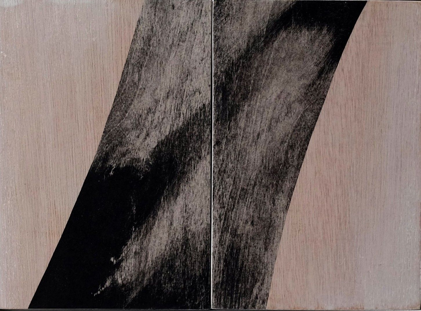 Close-up of black textured fabric folds against a light wood background