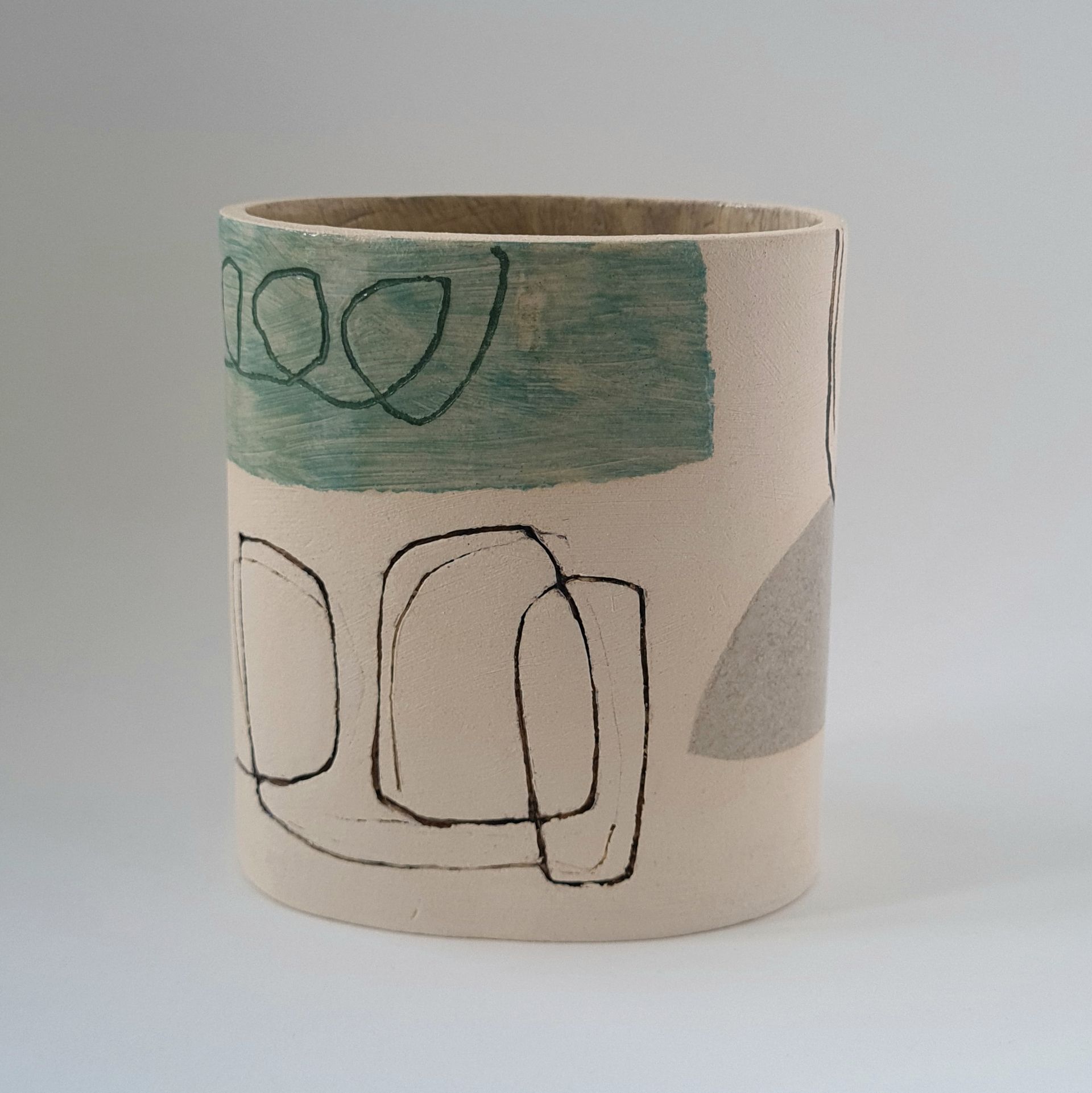 a white cylinder with a green and black design on it