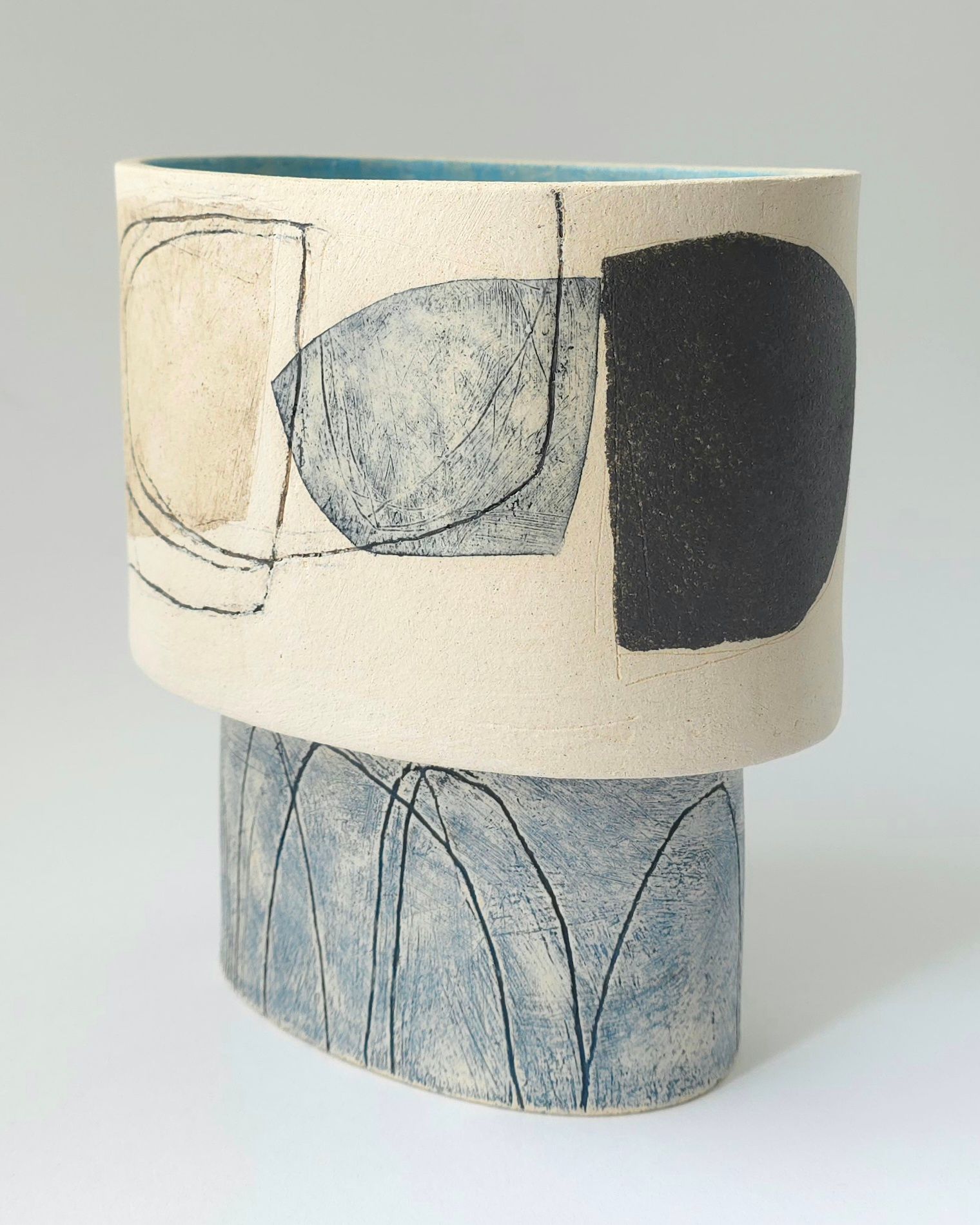 A ceramic vase with a black and white design on it