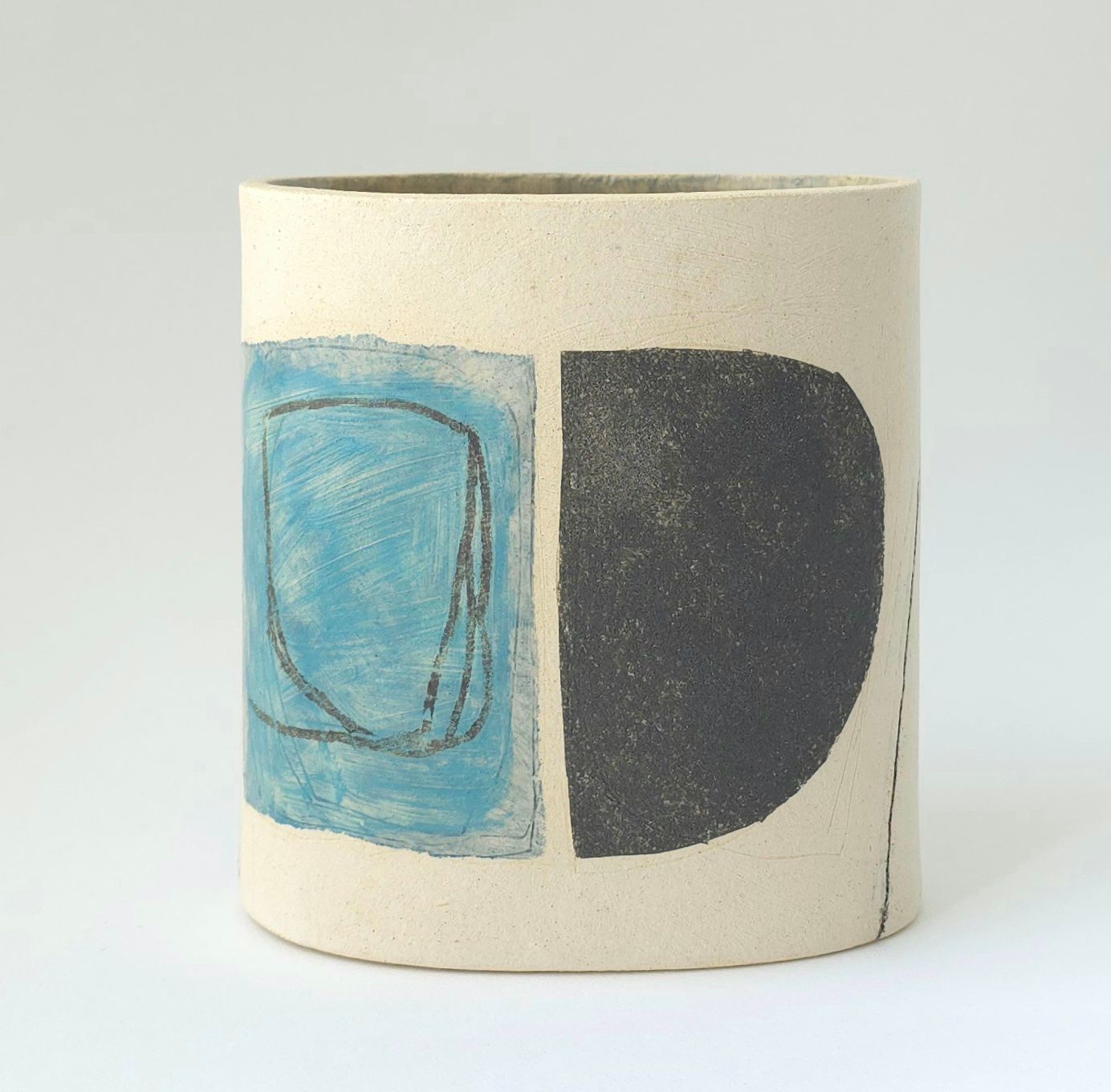 A white vase with a blue and black design on it