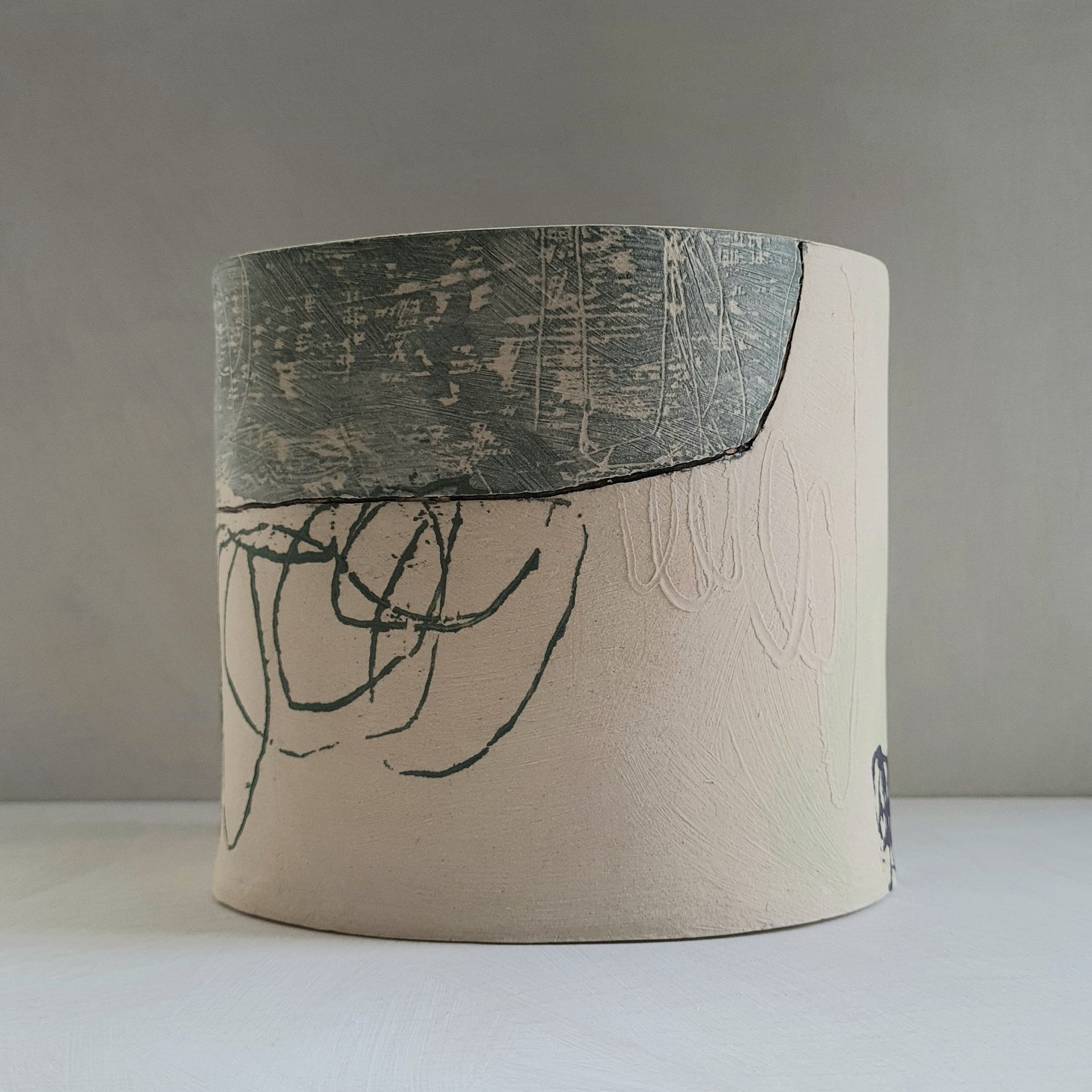 a ceramic vessel with a drawing on it is sitting on a table .