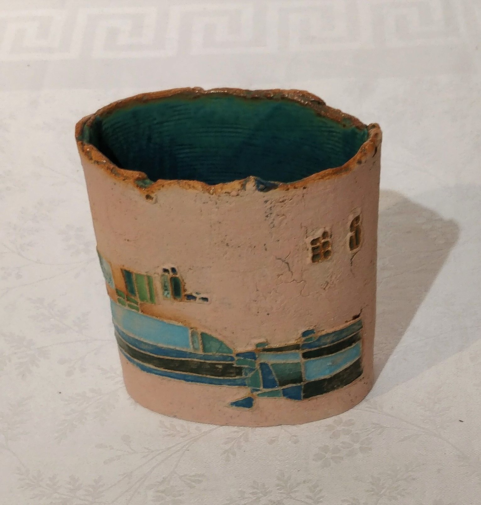 a ceramic vessel with a greek key pattern on it