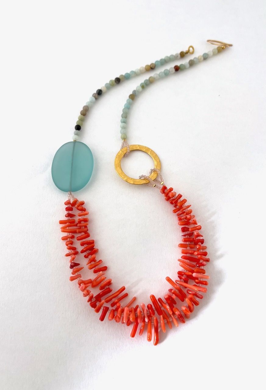 A necklace with red beads and a blue circle