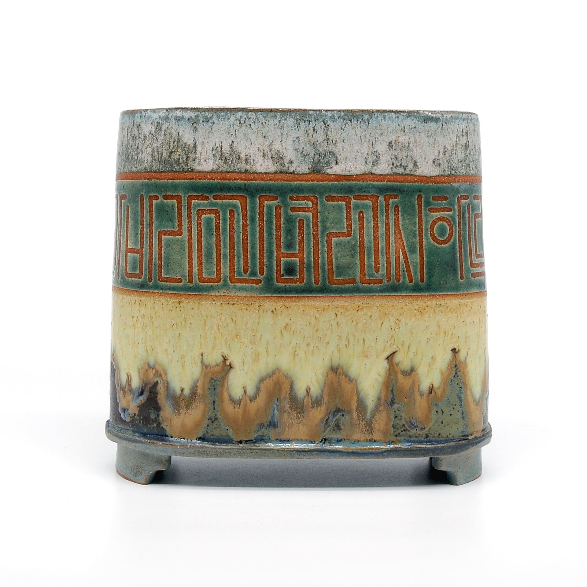 A ceramic vase with a greek key design on it