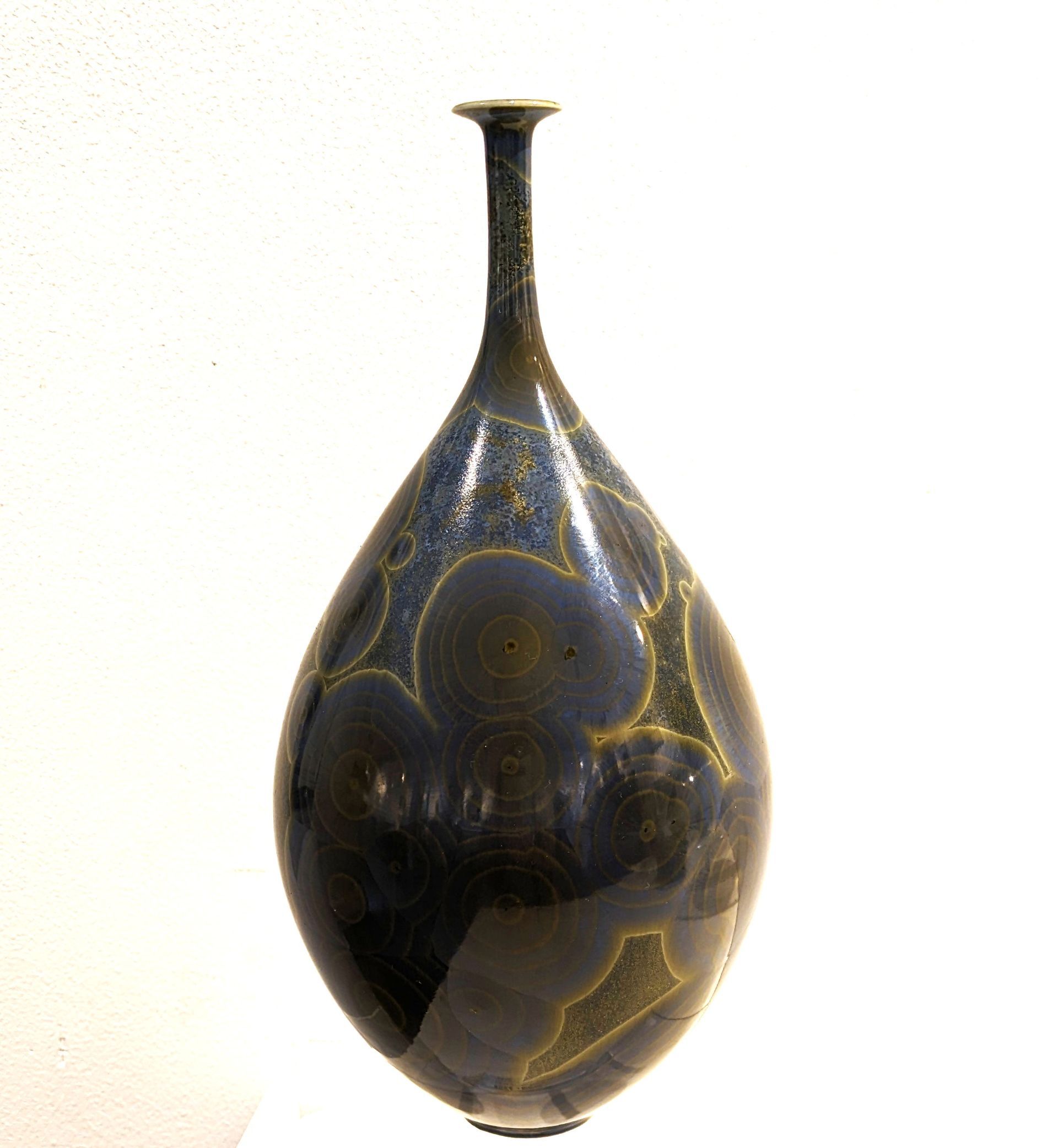 a vase with a long neck and a pattern on it