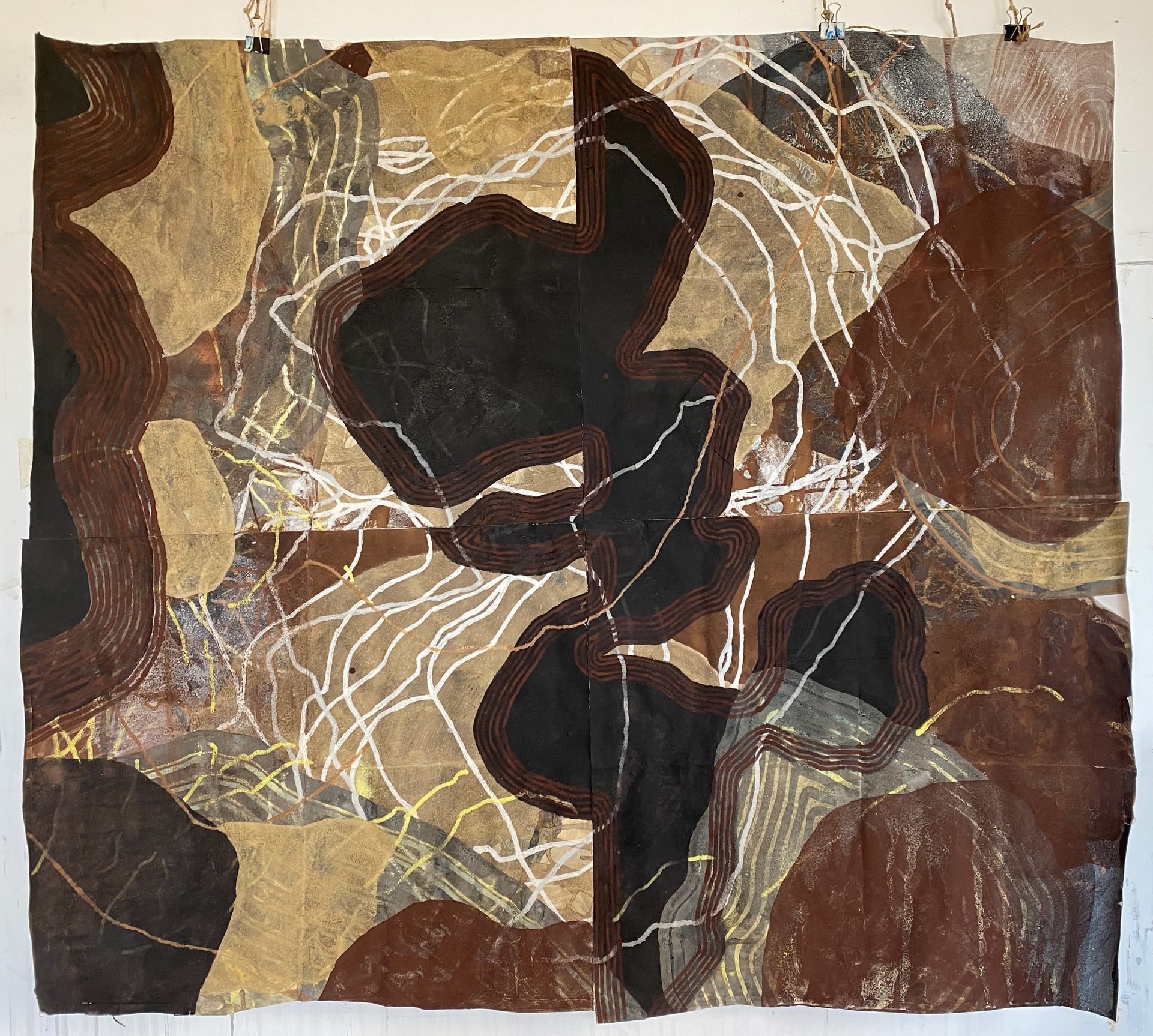 Abstract wall hanging of brown and black fabric patches with textured white line embroidery resembling a map or terrain.