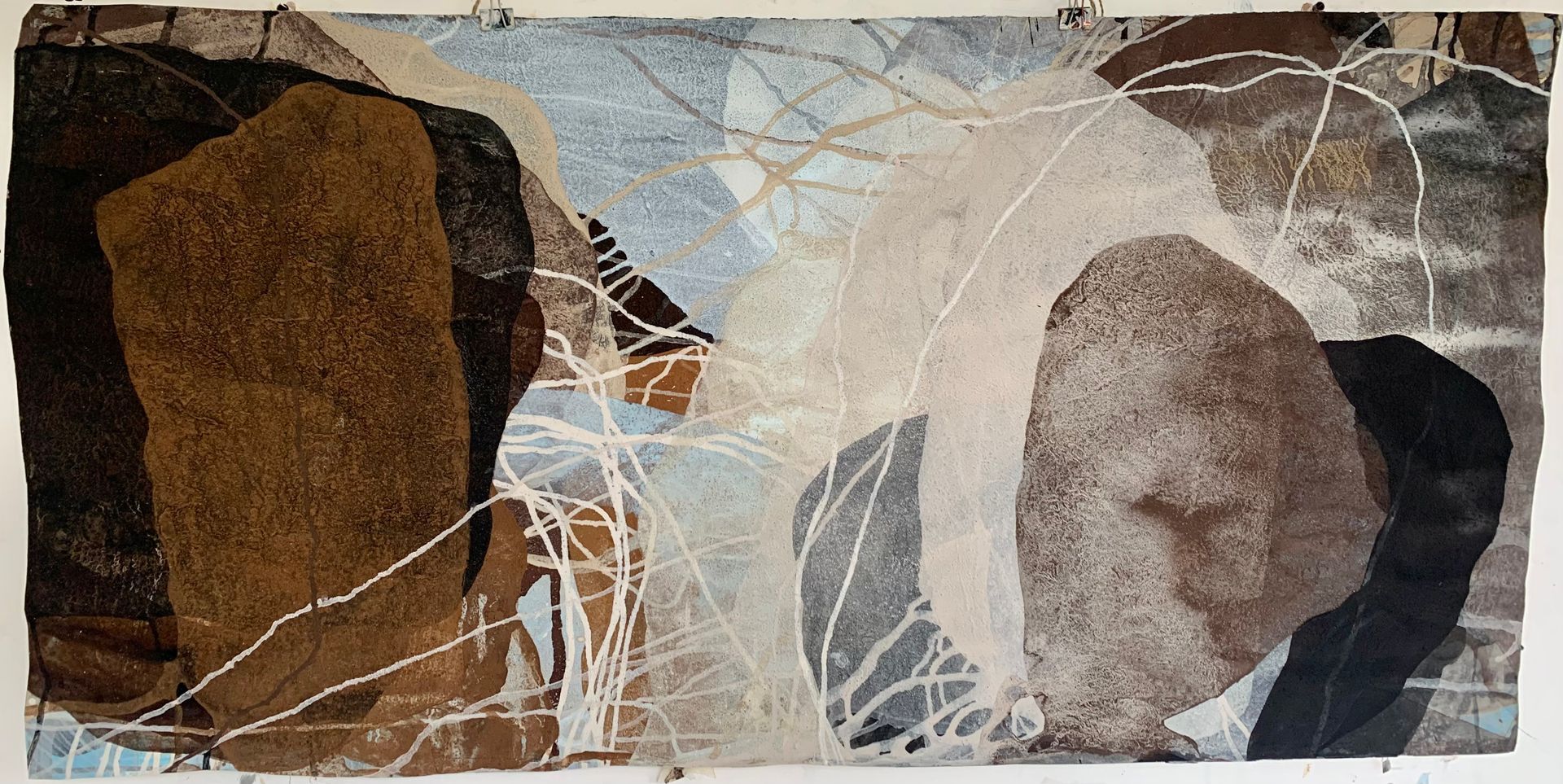Abstract tapestry featuring organic shapes in shades of brown, white, and grey with tangled white thread overlays.