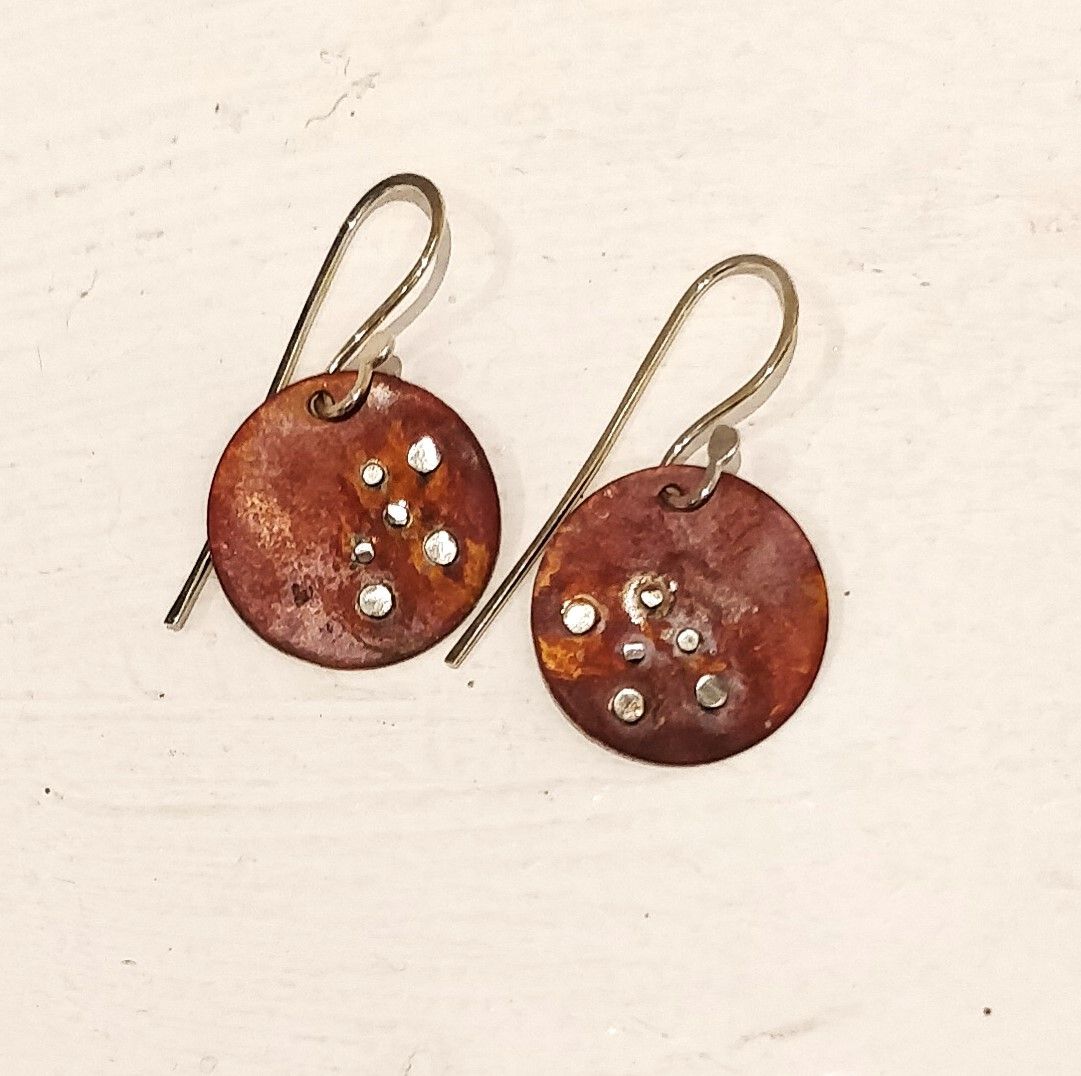 A pair of earrings are sitting on a white surface