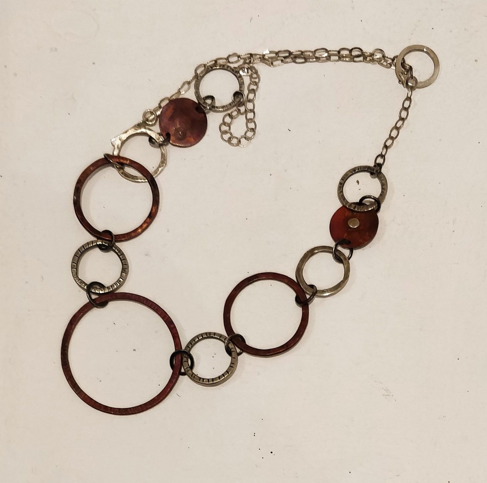 a necklace with circles and beads on a chain