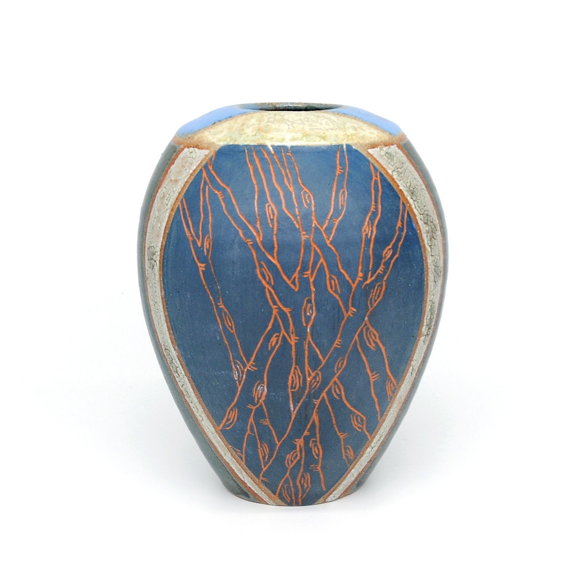 A blue vase with a tree design on it