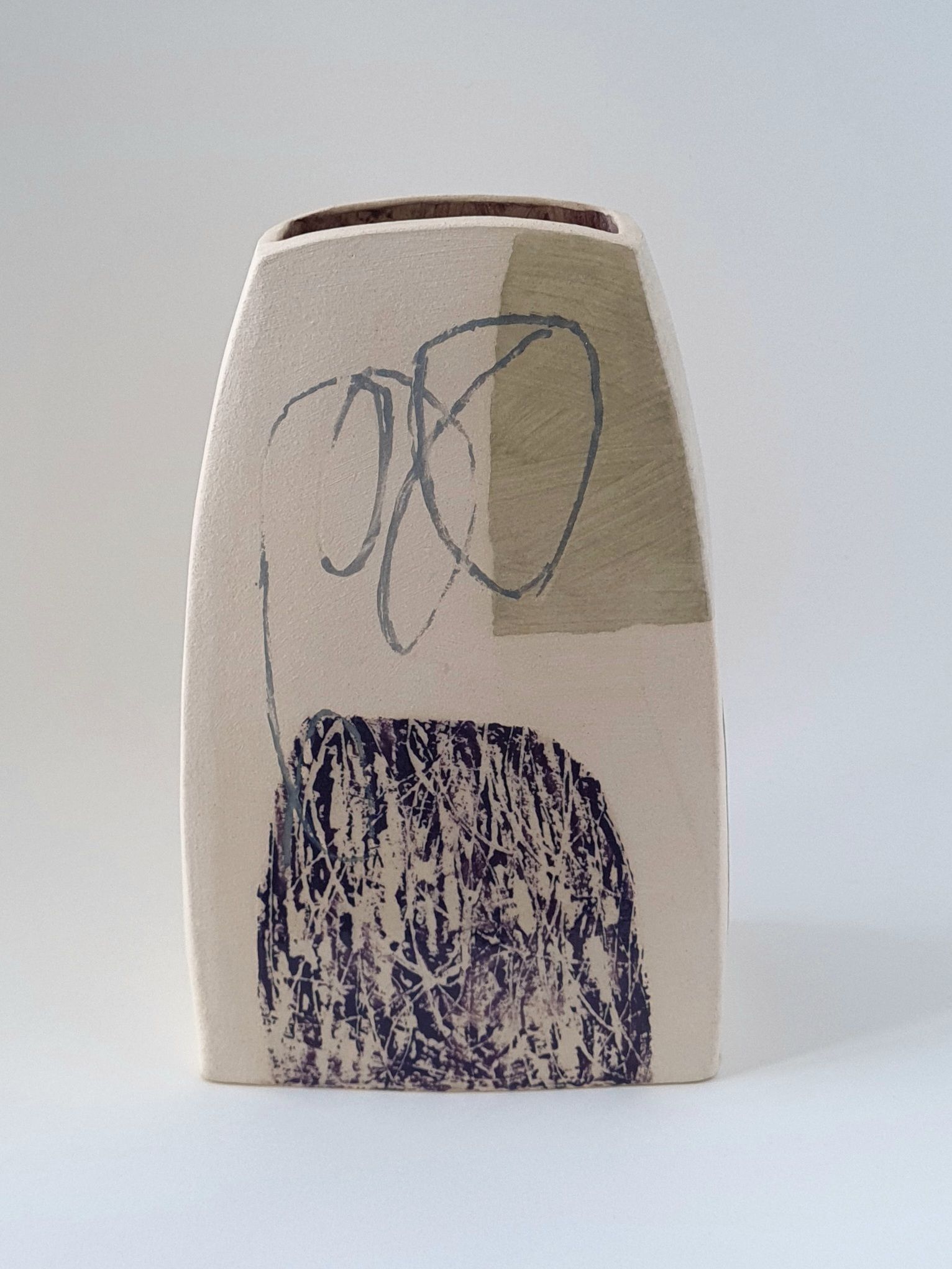 A white vase with a drawing of a person on it